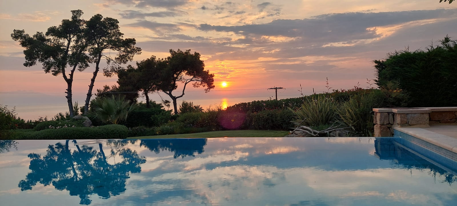 Private pool at sunset with sea reflection